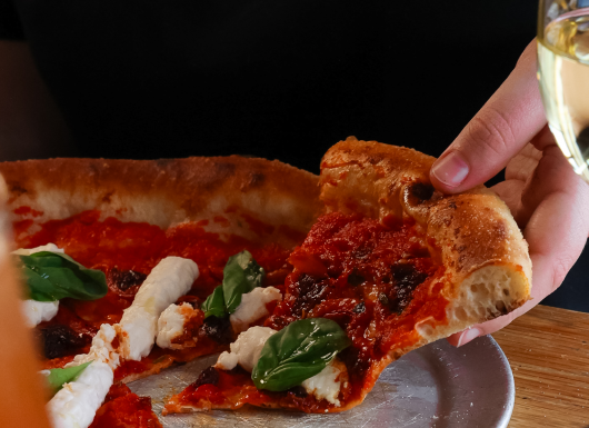 GRR PIZZA EAST SHOREDITCH MARCH 2026 SPRING SUMMER MENU SHOOT HAND HOLDING VEGAN PIZZA world cup 10.6.26
