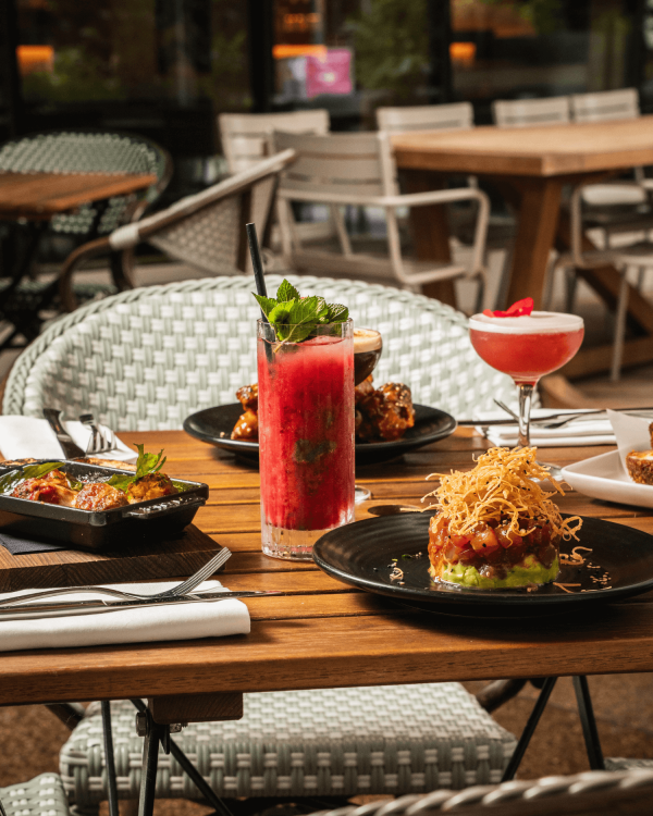 Cocktails and plates of food served in the terrace of Bread Street Kitchen