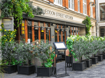 The front entrance and outdoor dining area of Heddon Street Kitchen Restaurant in Soho.
