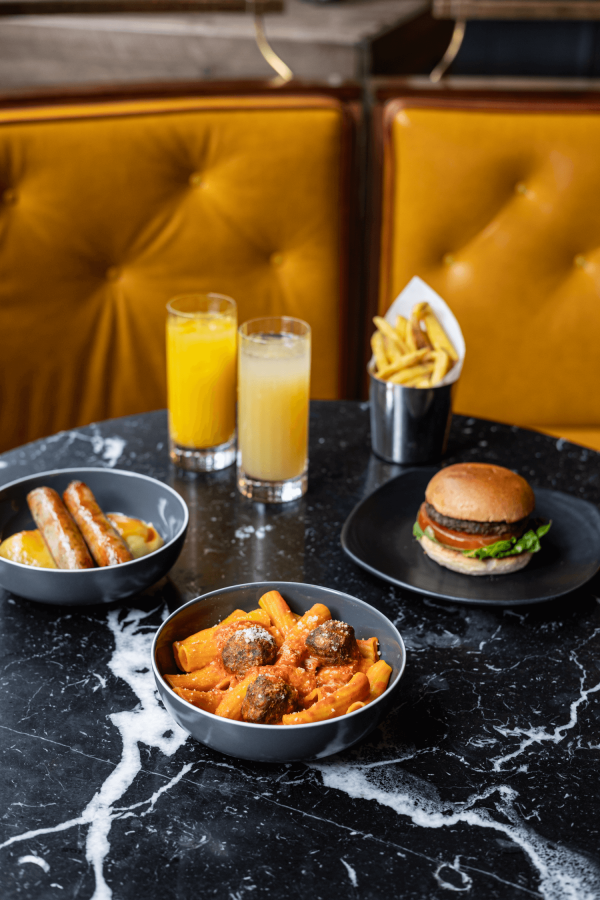 Three plates, including Sausages, Meatballs & pasta, and a Burger & fries from the Gordon Ramsay Kids menu.